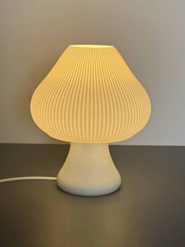 Luminária Groove Cogumelo acesa sobre mesa, feita em PLA bioplástico sustentável